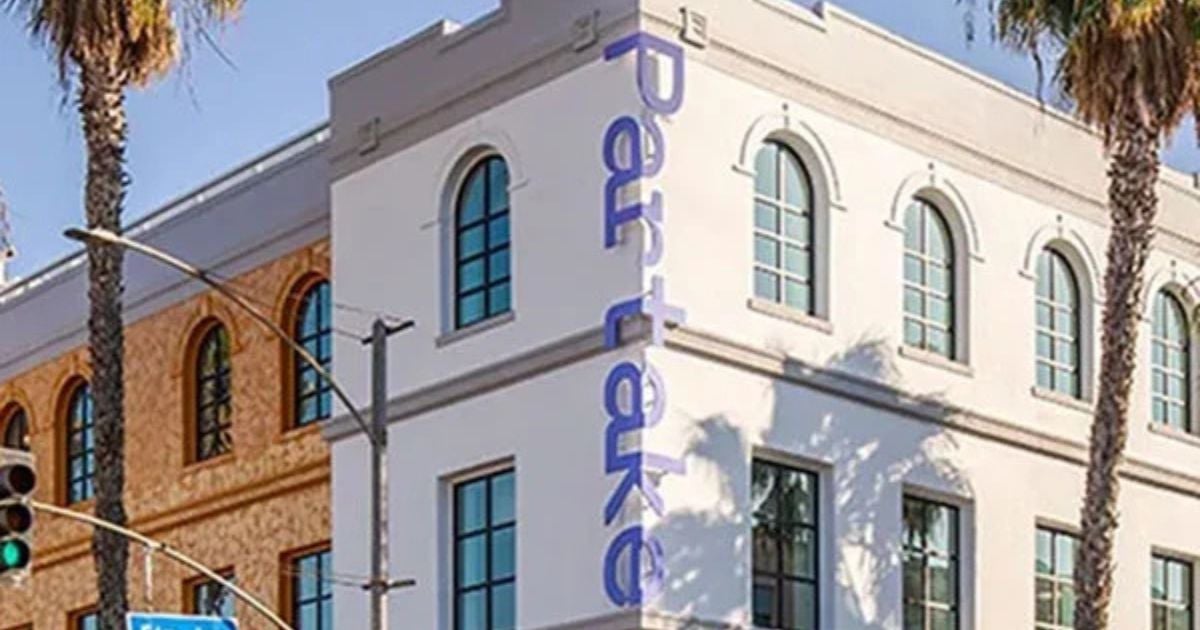 the building exterior with Partake signage, palm trees
